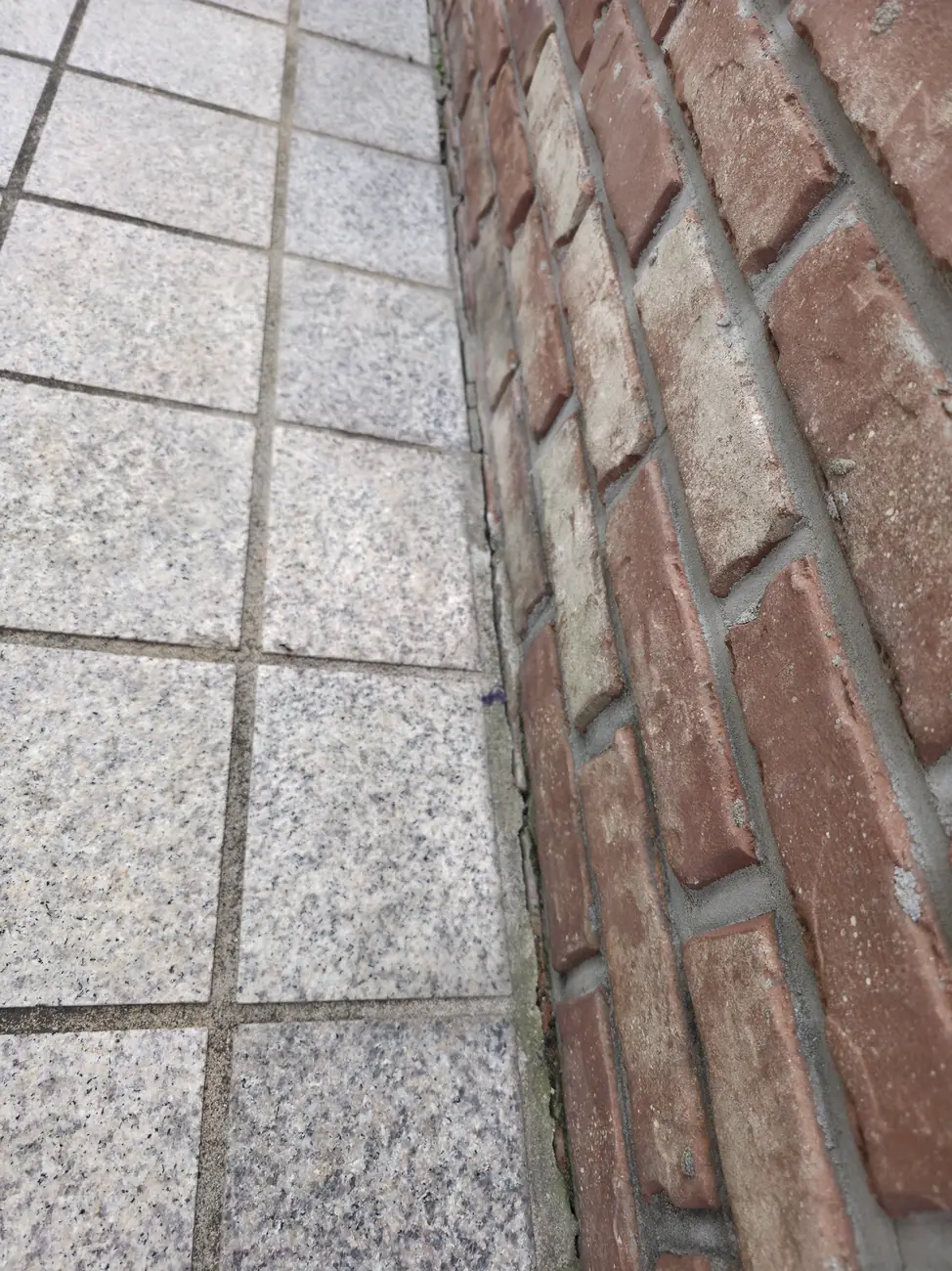 아파트 단지 주차장 구획선 인근 판석이 깨진 유사 시공 예시입니다.